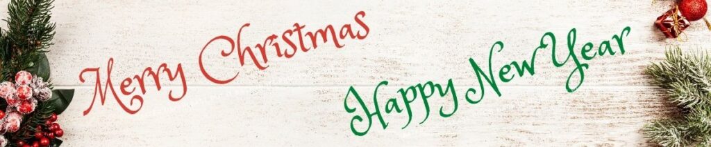 A red "Merry Christmas" and a green "Happy New Year" on a gray board with Christmas greenery.