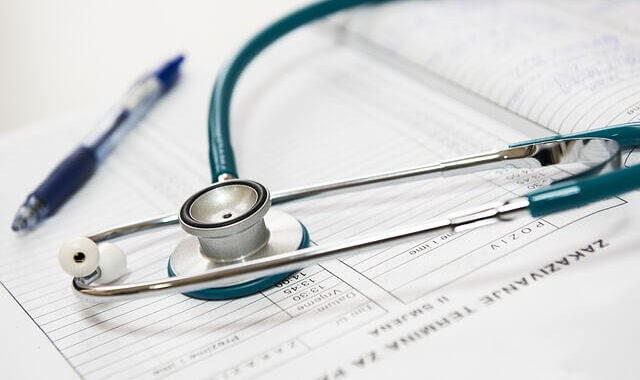 Stethoscope and pen on top of paper.