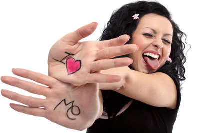 A funny meme of "I Love Me." A woman is holding out her hands with I heart Me on them. She is laughing, sticking out her tongue. She has black hair and is wearing a black blouse.